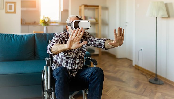 Senior im Rollstuhl und mit Virtual Reality Brille