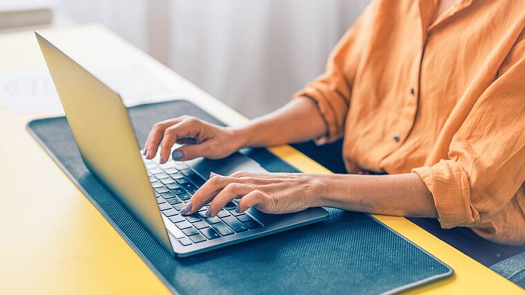 Nahaufnahme Frau/Physiotherapeutin tippt auf der tastatur ihres Laptops