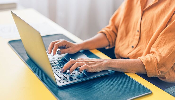 Nahaufnahme Frau/Physiotherapeutin tippt auf der tastatur ihres Laptops